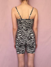 Load image into Gallery viewer, Back view of size 8 Tall white model wearing black and white, zebra print, jersey unitard bodysuit stood in front of pink fabric background.