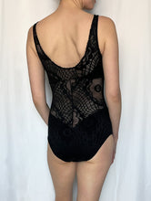 Load image into Gallery viewer, Back view of size 8 tall white model wearing black lace cutout bodysuit stood in front of white fabric background.
