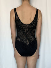 Load image into Gallery viewer, Back view of size 8 tall white model wearing black lace cutout bodysuit stood in front of white fabric background.
