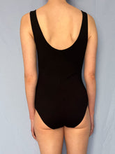 Load image into Gallery viewer, Back view of size 8 Tall white model wearing black viscose jersey vest bodysuit stood in front of blue fabric background.
