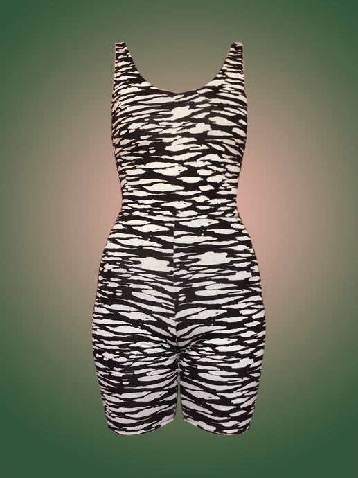 Deadstock black and white zebra print unitard in front of green and pink ombre background 